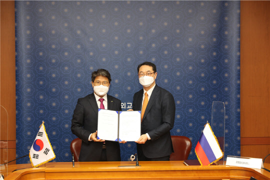 장충모(사진 왼쪽) LH 부사장이 '연해주 한·러 경제협력 산업단지' 개발 사업이행약정서에 서명한 뒤 김건(사진 오른쪽) 외교부 차관보와 기념사진을 촬영하고 있다. <LH 제공>